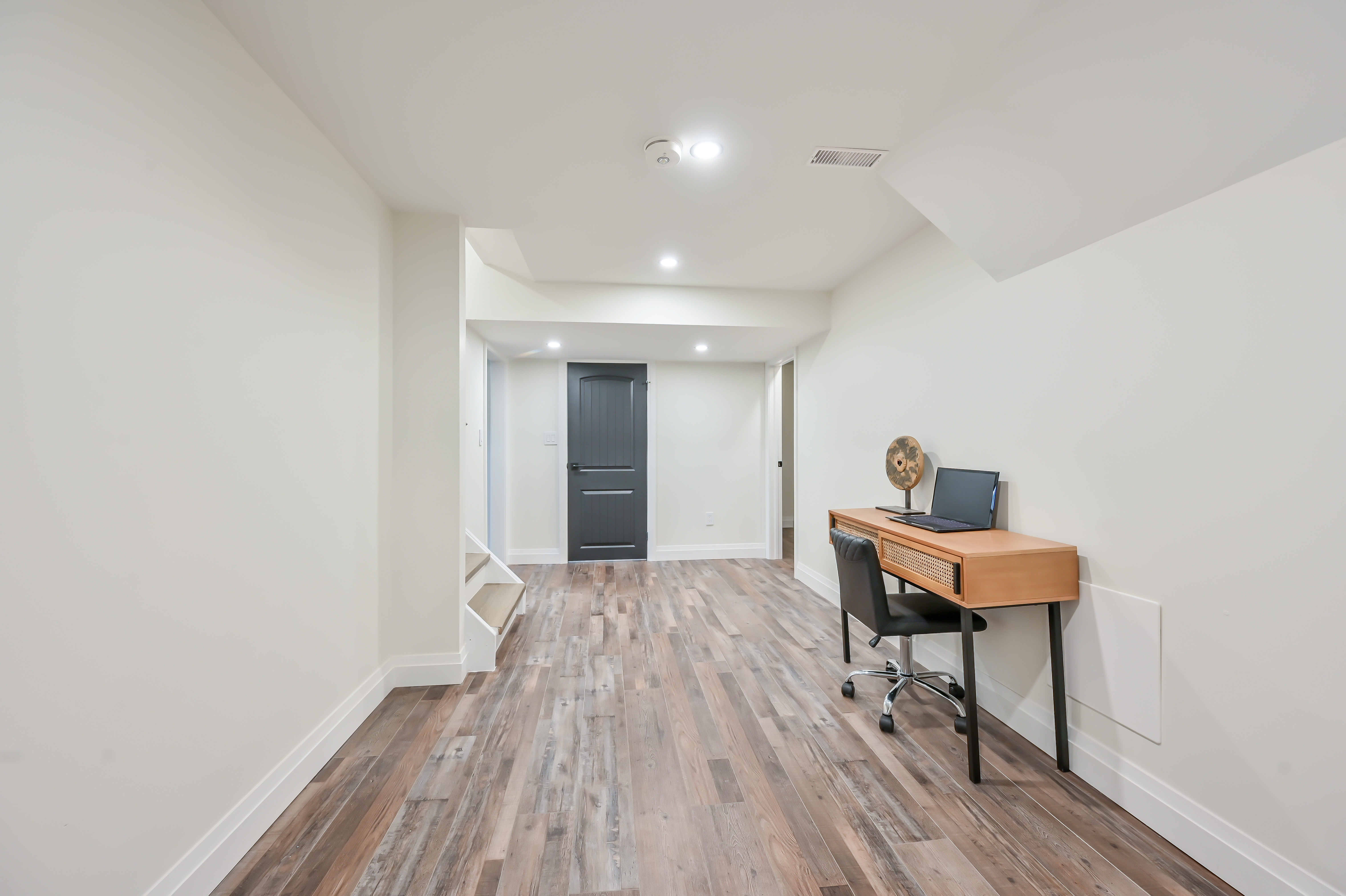 Clean finished basement with excellent lighting and staging — premium portfolio shot showing complete transformation — Kron, Hamilton | MTC Renovations